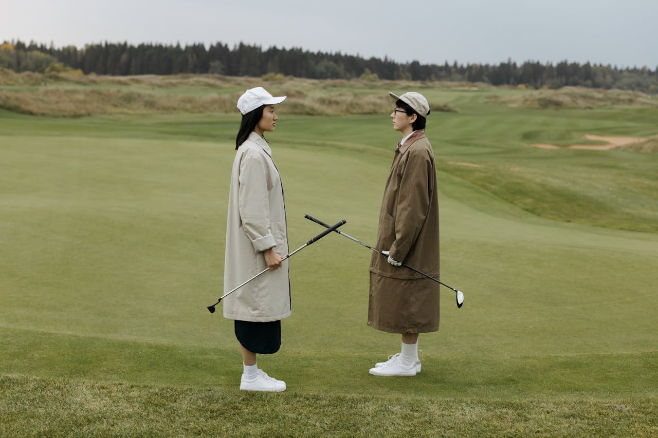 Two People Standing on Golf Course Face to Face